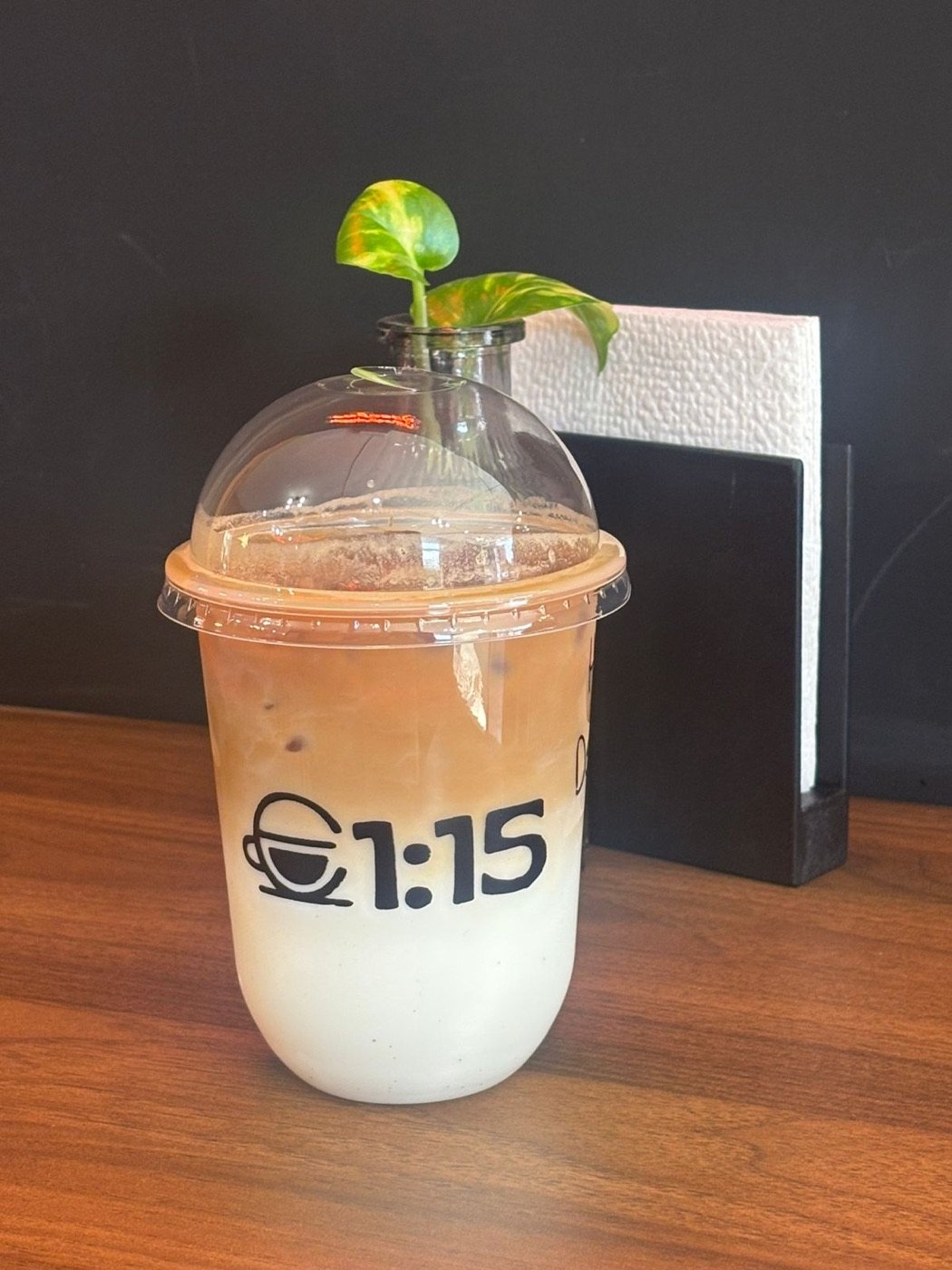 Café helado en vaso con el logo de 1:15