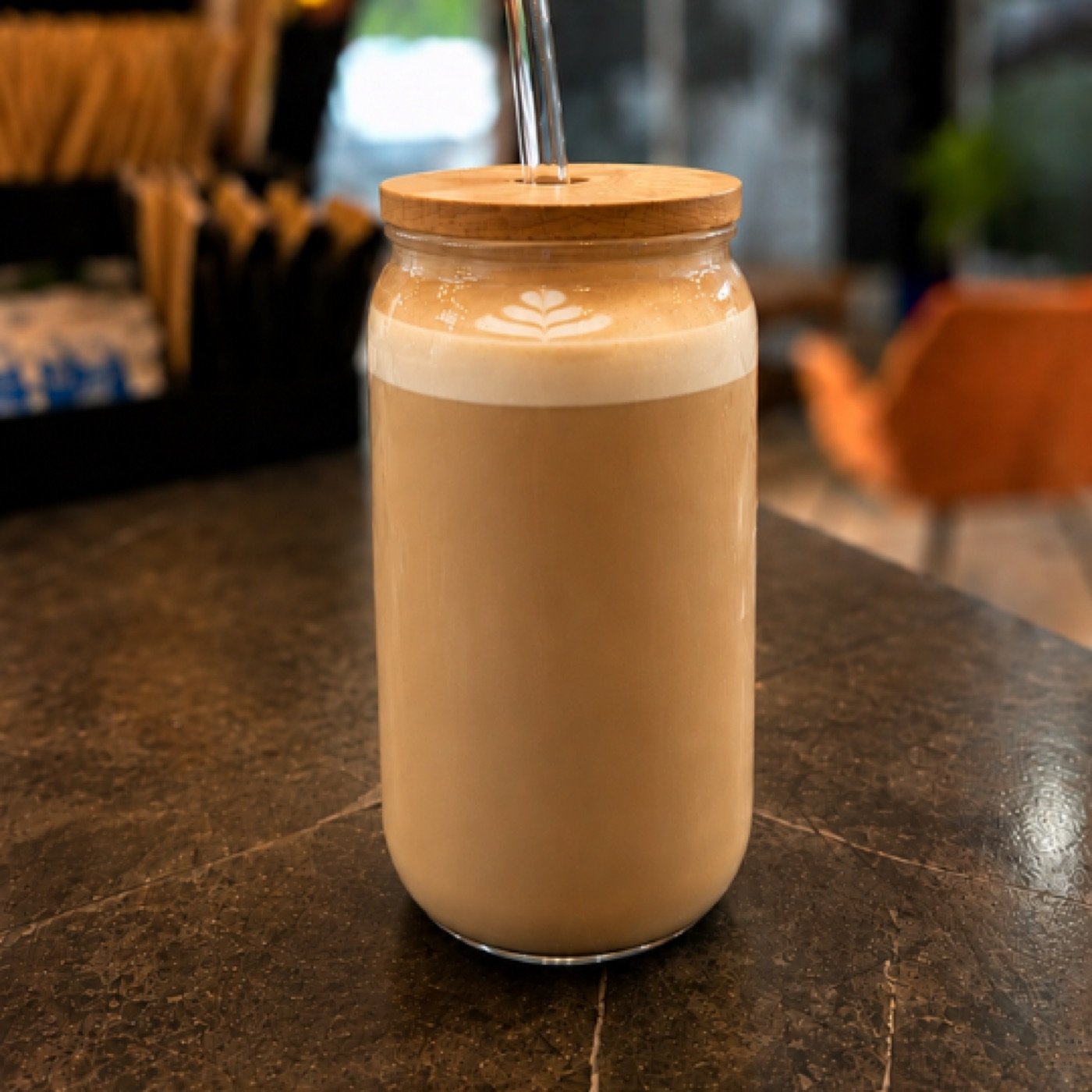 Iced latte en vaso de vidrio con tapa de bambú